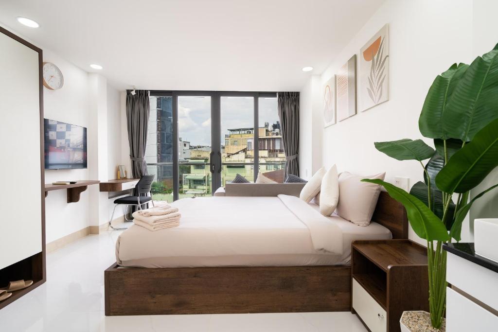 Queen studio room with a work desk and floor-to-ceiling window at Ekomo Home 95 - Metro Ben Thanh