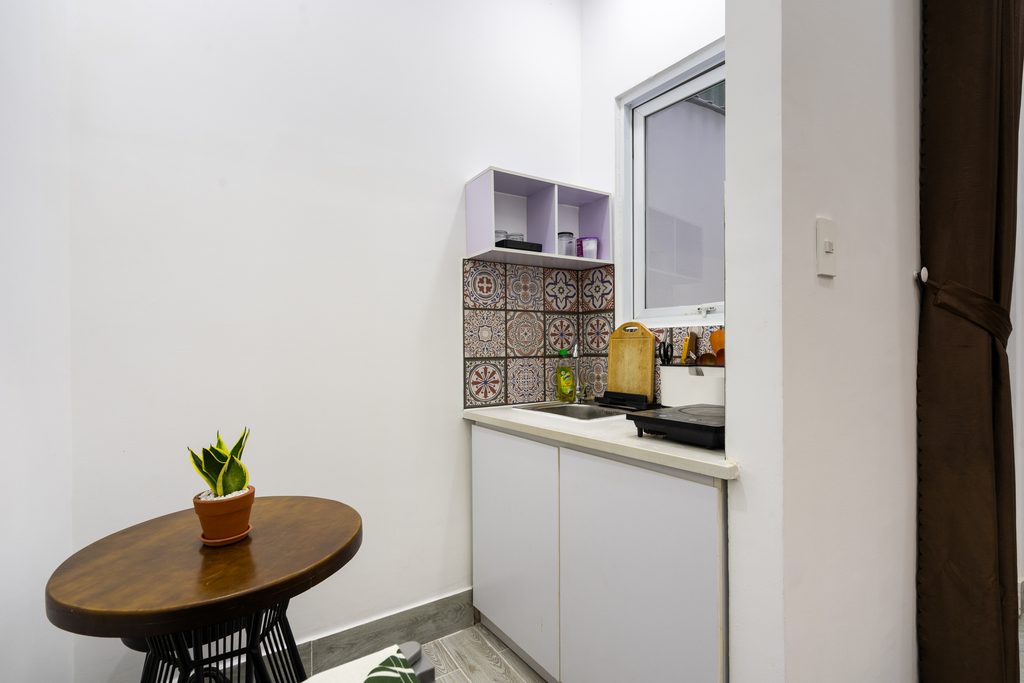 In-room kitchen with patterned tile backsplash at Ekomo Home 102 - Central Saigon